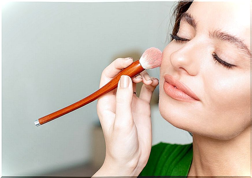 Woman applying makeup for dry skin.