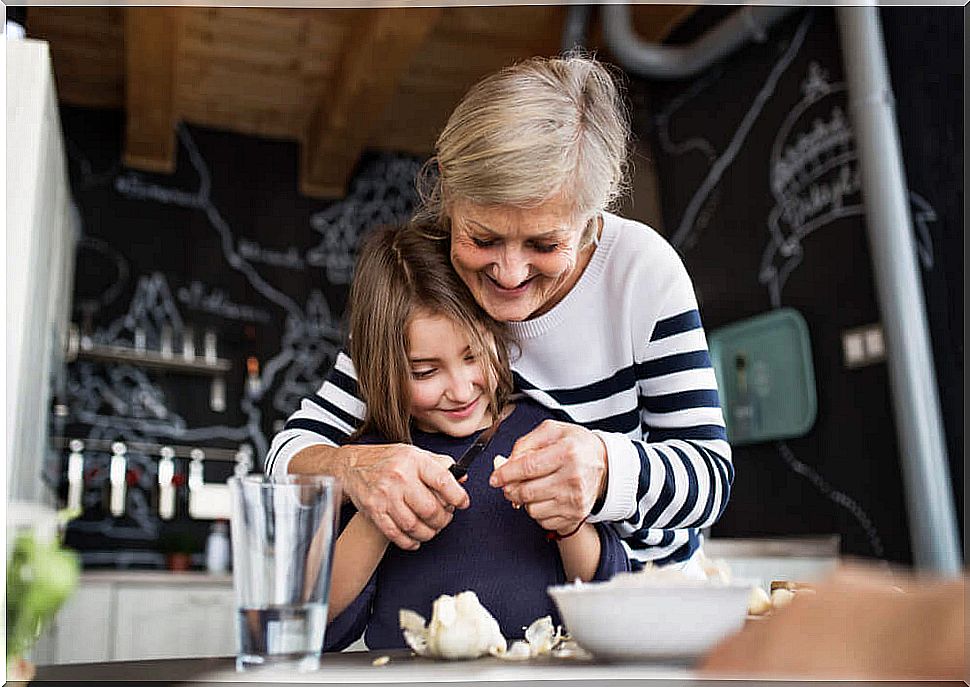 Grandmother teaching her granddaughter to cook.