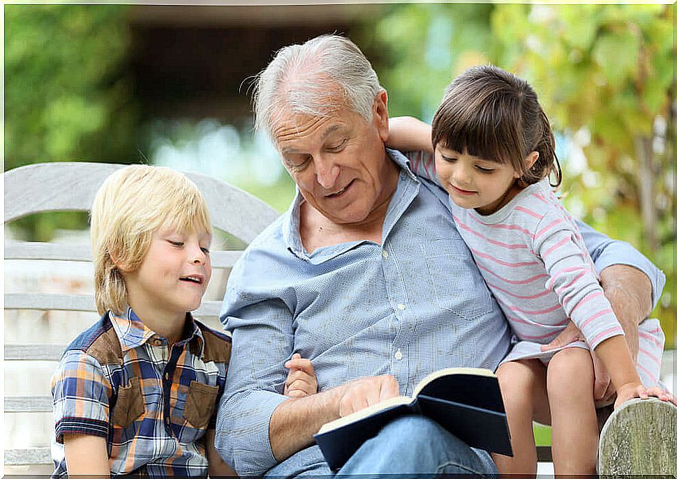 Grandfather reading with grandchildren.