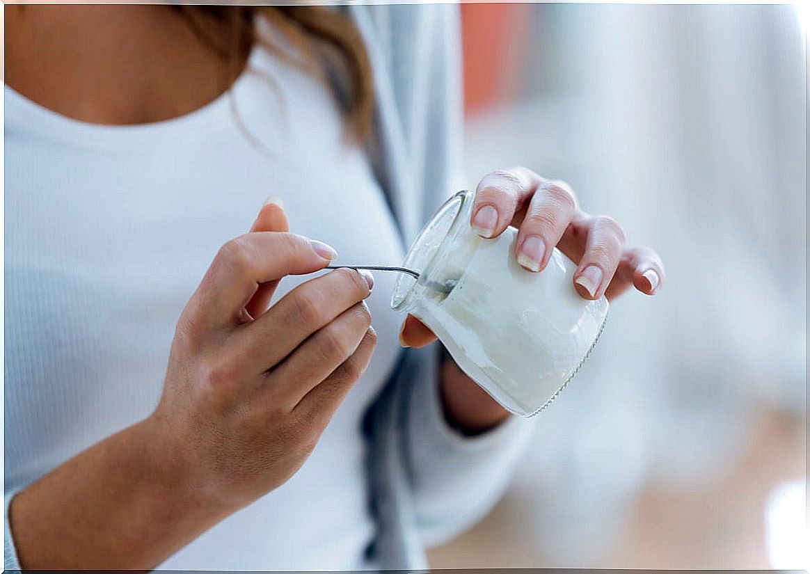 Woman eating natural yogurt.