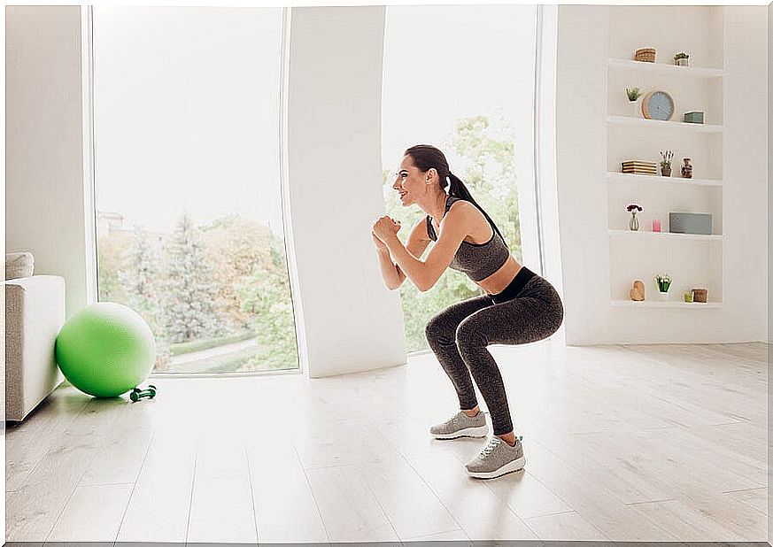 Woman doing squats at home.