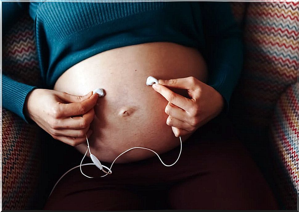 Pregnant belly with headphones on it to apply the Mozart effect.